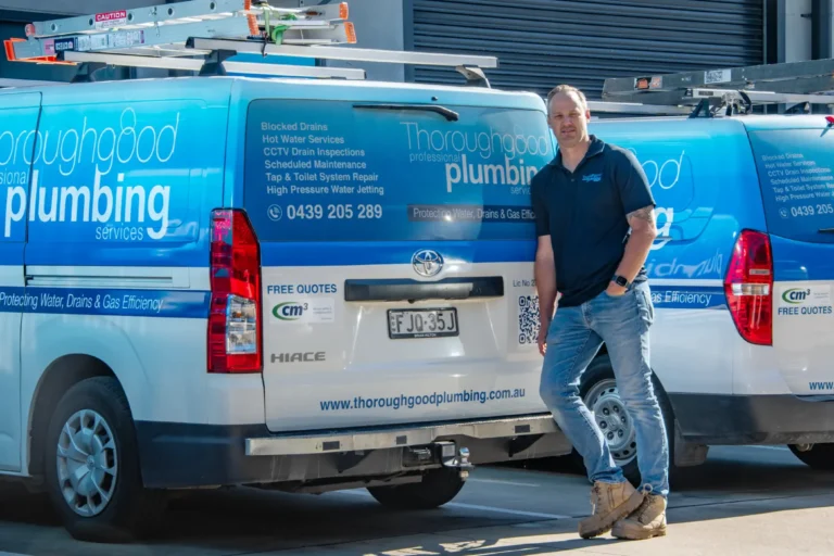 Thoroughgood Professional Plumbing Services owner standing in front of branded Toyota HiAce fleet vans, Central Coast NSW